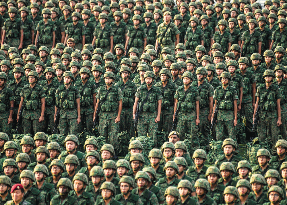 Image of many rows of Asian soldiers, standing at attention, wearing green fatigues
